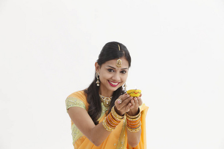 戴着油灯的迷人传统服装的印度女人