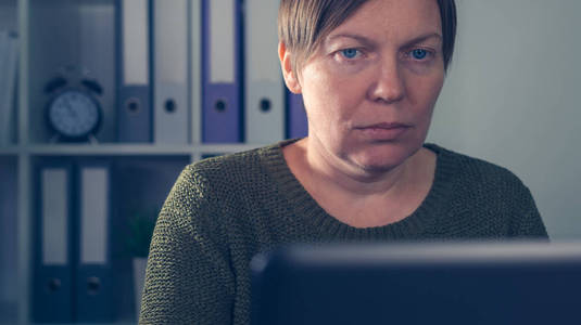 疲惫疲惫的女性自由职业者在笔记本电脑上工作