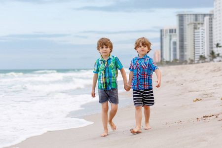 两个小孩子运行在海洋沙滩上的男孩