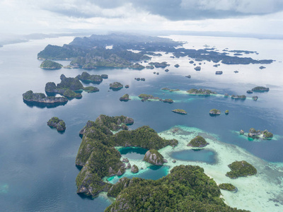 崎岖的石灰岩岛屿发现附近的错位拉贾安帕特上升从平静的海洋在印度尼西亚东部的偏远地区。 这个美丽的热带地区以其非凡的海洋生物多样性