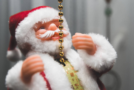 圣诞老人的景色。 玩具圣诞老人红色帽子手举起来。 圣诞节即将来临，送礼物玩具。 圣诞气候概念。 接受礼物的儿童的幸福和满意。