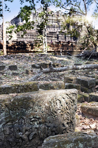 吴哥的Phimeanekas寺庙或Vimeanakas废墟是一座印度教寺庙，10世纪是暹粒柬埔寨。 专注于前景中的一块石头