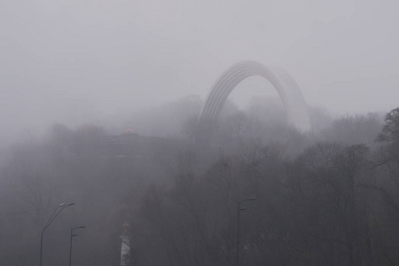 人们的友谊拱门在丰富的雾中, 雾的背景。晨城景观。乌克兰基辅