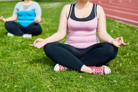 横腿丰满的女性在户外练习瑜伽
