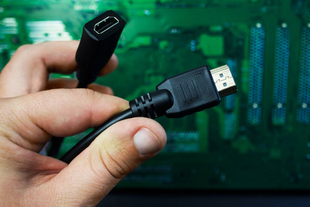 第一人称视图手握HDMI电缆在计算机电路板上。