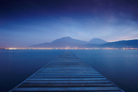 海上日落和天空反射水的木码头。长时间曝光