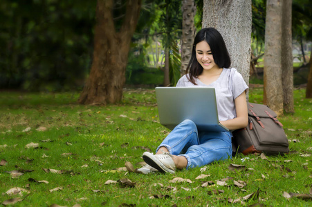 一个学生坐在笔记本电脑和放松的美丽的女人