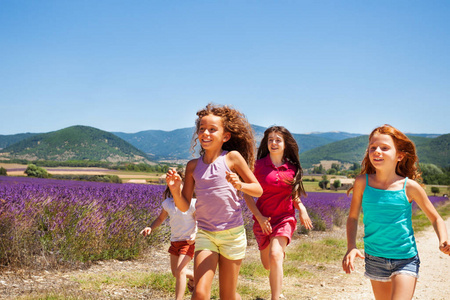一群四岁的不同女孩快乐的玩伴在夏天的薰衣草花田里跑来跑去