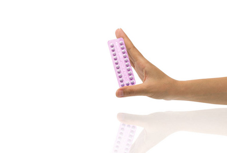 亚洲年轻女子手持一包避孕药, 一只手在白色背景下, 复制空间和修剪路径隔离。用节育丸概念选择计划生育