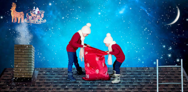 圣诞快乐，节日快乐孩子们打开一袋圣诞老人的礼物。 圣诞老人把一袋礼物扔给了房子屋顶上的小孩子。