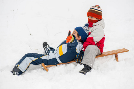 快乐顽皮的孩子在雪地里雪橇