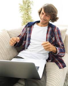 快乐的年轻人看着手提电脑的屏幕