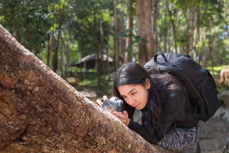 亚洲妇女背包拍照与 mirrorless 相机