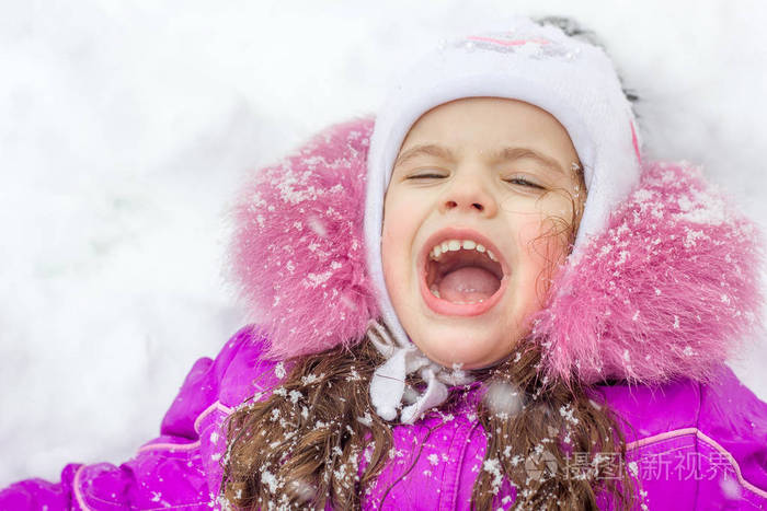 白雪皑皑的冬天,一个滑稽的小女孩张开嘴,接住雪花