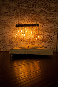 漂亮舒适的阁楼风格房间。 卧室配有大床白色床单和上面的灯