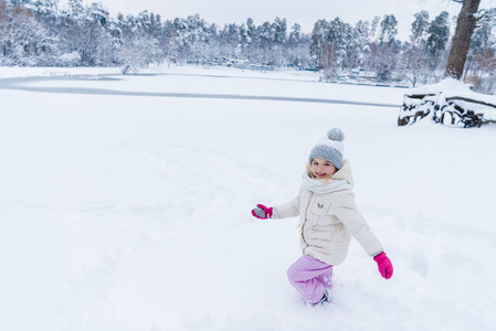 可爱的快乐孩子在冬天公园玩雪，对着镜头微笑