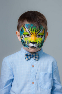 一个小男孩的肖像画像老虎孤立在灰色背景