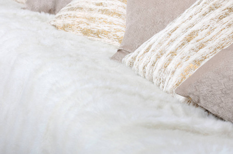 许多枕头躺在沙发上，沙发上铺着一层长毛绒面纱