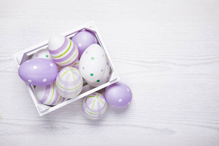 白色篮子中的紫色复活节彩蛋的顶部视图。复活节 backgroun