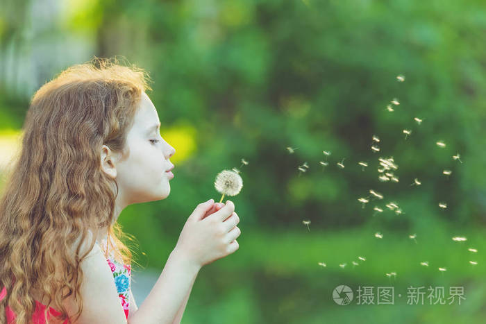 可爱的孩子在春天公园吹蒲公英. 健康的医疗理念.
