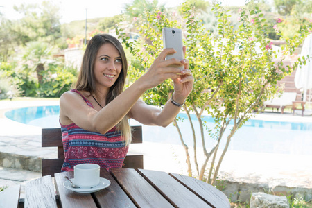 女性坐在泳池附近，夏天，自拍拍照喝咖啡茶博斯卡达卡卡勒，土耳其，2017年