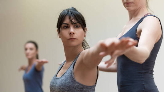 瑜伽教练和妇女伸展手臂