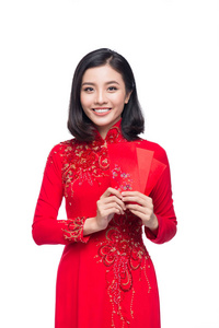一位美丽的亚洲女人在传统节日服装上的肖像，戴着红色的零花钱。 泰特假日。 农历新年。