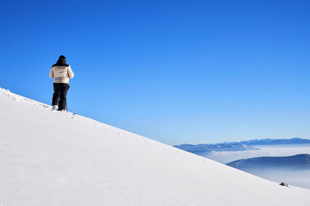 瑞士阿尔卑斯山日出时，滑雪观光者到达山顶。