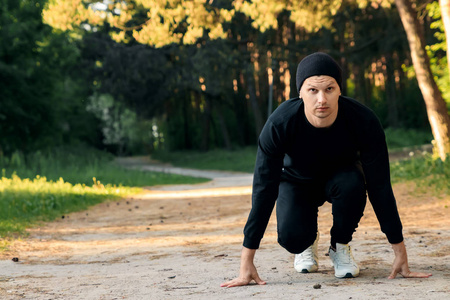 一个男人正在做运动，准备在一个绿色的公园里做晨练，在一个夏天的晨练空间里