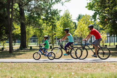 快乐的家庭一起骑自行车在公园里