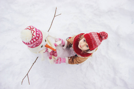 冬天在雪地里的孩子。 堆雪人。 选择性聚焦。