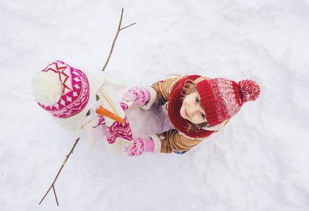 冬天在雪地里的孩子。 堆雪人。 选择性聚焦。