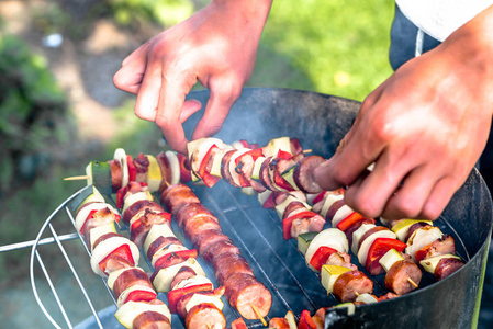 烧烤烤肉串在夏日花园, 厨师的手准备 shashliks 与蔬菜和肉类, 户外烧烤草