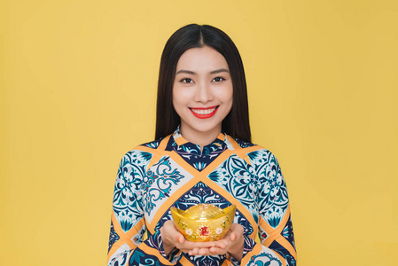 穿着黄色背景的传统服装的有魅力的越南女人