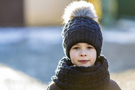 在阳光明媚的冬天, 在户外戴着帽子和围巾的孩子的画像
