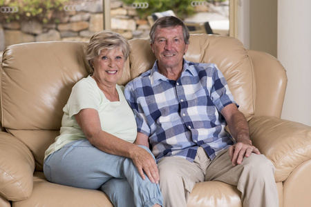 年长的美丽中年夫妇在70岁左右笑开心一起在家里客厅沙发沙发看起来甜美的一生的爱