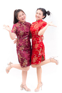 身穿中式旗袍的年轻亚裔女子, 带着祝贺的姿态, 在中国新年庆典上看着镜头微笑, 在白色背景下庆祝新年
