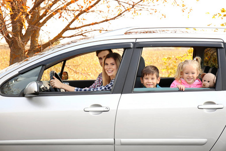 年轻夫妇与他们的孩子在农村道路上的车