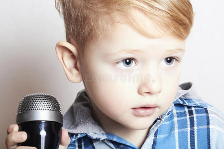 小男孩在麦克风里唱歌。卡拉OK的孩子。音乐