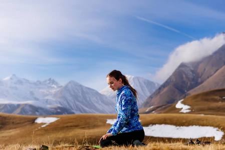 女孩游人坐在高山背景