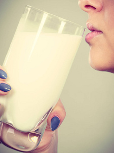 女人从玻璃喝牛奶