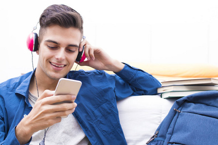 青少年用手机和耳机听音乐