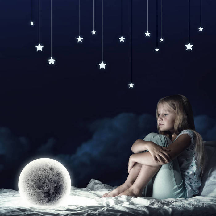 可爱的女孩坐在床上看着月亮星球