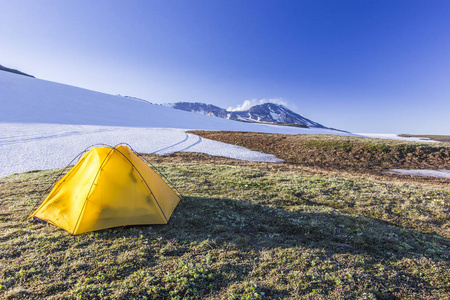 日出时在勘察加的火山附近的黄色帐篷