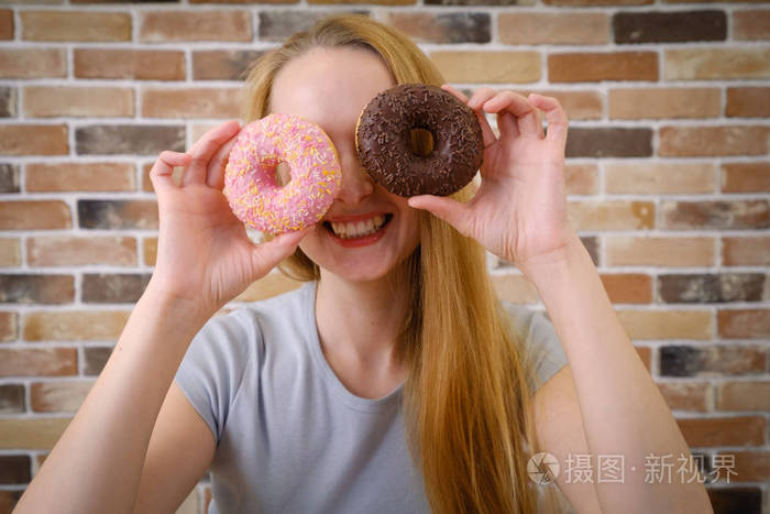 特写微笑的女人有乐趣与甜甜圈