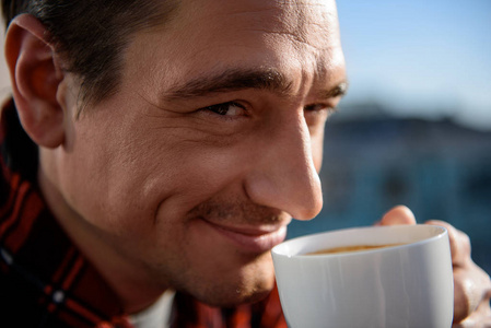 满足成年男性微笑和饮用咖啡
