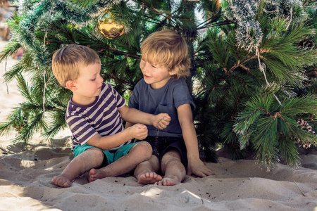 两个男孩正在海滩上庆祝圣诞节。