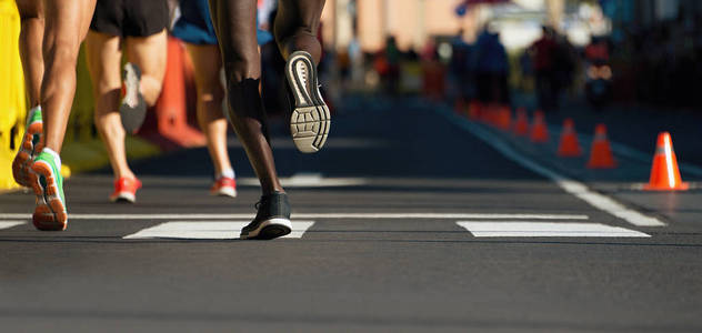 跑在城市道路上的马拉松运动员腿上的细节