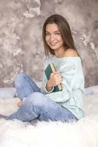 年轻美丽的白种女人坐在床上看书