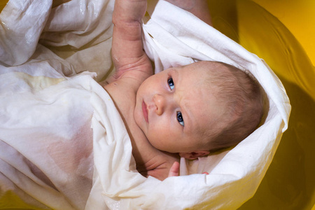 新生儿在白色尿布在黄色浴。顶部视图